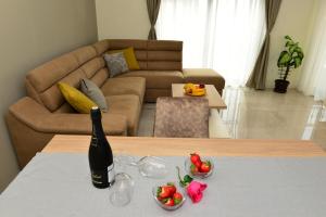 蒂瓦特Ralux apartman Tivat的一瓶葡萄酒和两碗水果放在桌上