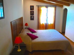 科尔巴拉A ChiOsella的一间卧室配有一张带紫色枕头的床和窗户。