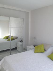 戛纳Appartement vacances cannes的白色卧室配有床和镜子