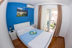 布德瓦Villa DiEden的卧室配有白色床和蓝色墙壁