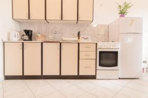 佩罗杰Apartman Deni的厨房配有白色橱柜和白色冰箱。