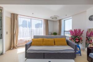 大连大连修竹大厦酒店式公寓的客厅配有带黄色枕头的沙发