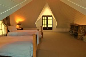 伯格维尔Dalmore Guest Farm的阁楼卧室设有两张床和窗户。