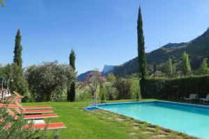 拉纳Hotel Burgleitenhof的一座位于花园内的游泳池,花园内以群山为背景