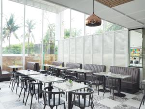 当格浪d'primahotel Airport Jakarta 2的用餐室设有桌椅和窗户。