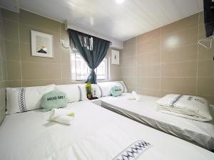 香港安逸宾馆的带窗户的客房内的两张床