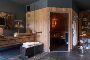 Saint-Jouin-Bruneval凯撒的松树 - 埃特勒特运动酒店的一间带木制梳妆台和玻璃门的浴室