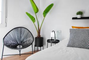贝尼卡洛Edificio Bel的一间卧室配有椅子和植物