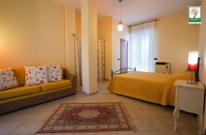 梅萨涅加蒂诺Il号德勒塞特住宿加早餐旅馆的一间卧室配有一张床、一张沙发和一个窗口