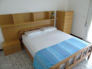 利尼亚诺萨比亚多罗斯伯汀公寓的一间卧室配有一张带木制床头板和架子的床。