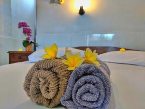八丹拜瑟兰干二世宾馆的床上的毛巾,上面有鲜花