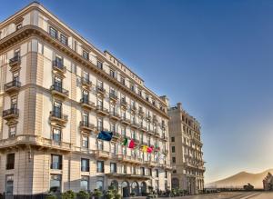 那不勒斯圣卢西亚大酒店的一座大建筑,上面有旗帜