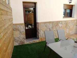La CodoseraApartamento La Sierra的客房 - 带两把椅子和一张桌子,铺有绿色地毯