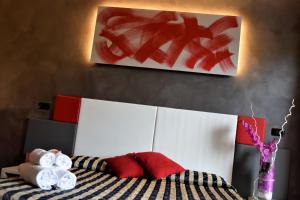 圣奇诺·迪·蒙塔尼亚科斯塔贝拉酒店的一张带红色和白色枕头的床和绘画