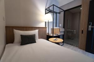 台东丰绮会馆的一间带白色大床的卧室和一间浴室