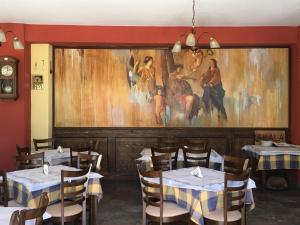 圣马太奥斯斯卡拉旅馆的一间设有桌子的用餐室和墙上的绘画