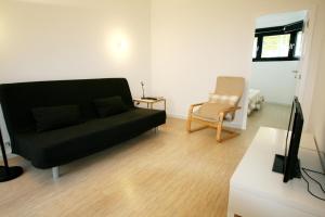 波尔图OPO.APT - 位于波尔图中心的装饰艺术公寓的客厅配有黑色沙发和椅子