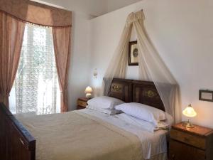 奥斯图尼马塞里亚里恩佐酒店的一间卧室设有天蓬床和窗户。