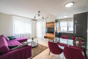 希欧福克Sprint Apartman的客厅配有紫色沙发和玻璃桌