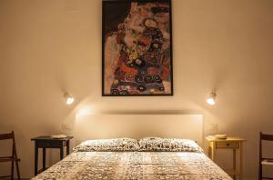 阿沃拉Casa D'Arte Shoshanna的卧室配有一张床,墙上挂有绘画作品