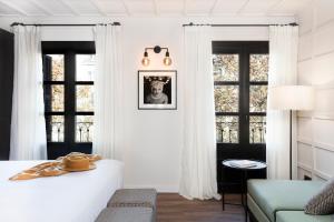 巴塞罗那Yurbban Ramblas Boutique Hotel的卧室配有白色窗帘和床