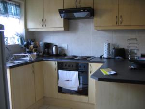 开普敦Malleson Garden Cottage的厨房配有炉灶和烤箱上的白色毛巾