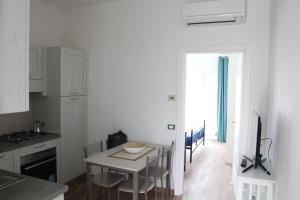 马萨Appartamenti La corte al Mare的厨房以及带桌椅的用餐室。