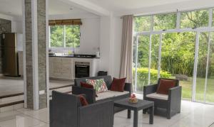 塔卡马卡Domaine Desaubin Luxury Villas的客厅配有两把椅子和一张桌子,窗户