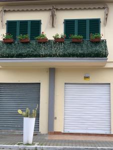 马萨Appartamenti La corte al Mare的两扇车库门,位于一座植物繁茂的建筑前