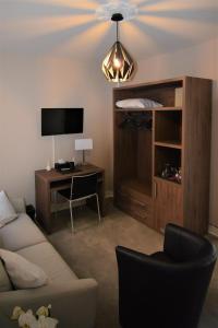 勒特雷波尔乐圣 - 伊夫酒店的带沙发、书桌和电视的客厅