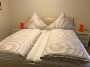 SassenbergPension zum Butterpatt的一张带两个枕头的床和两个橙色蜡烛