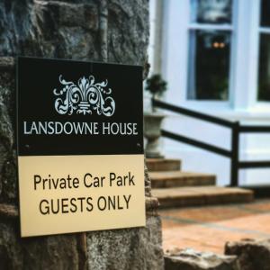 兰迪德诺Lansdowne House with Private Car Park的房屋前的树上的一个标志