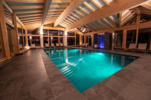 拉瓦罗内Caminetto Mountain Resort的大楼内的一个蓝色海水游泳池
