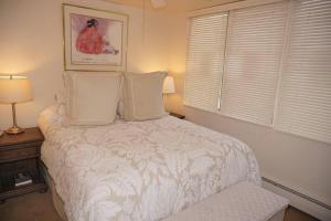 阿斯潘520 Cooper Ave E #305 (203040-6863) Condo的卧室配有白色的床和2个枕头