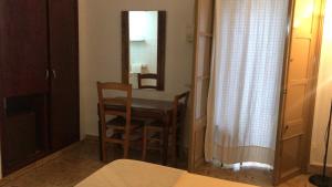 伊维萨镇佩纳旅馆的配有桌椅和镜子的客房