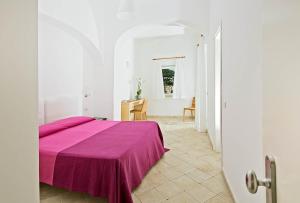 卡普里Hotel La Tosca的白色客房,配有一张带紫色毯子的床