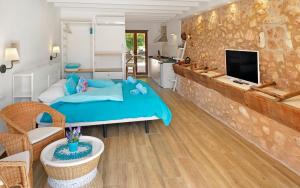费拉尼特斯Agroturismo Fincahotel Son Pou的一间带蓝色床的卧室和一间客厅