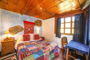 危地马拉安地瓜Yellow House Hostel B&B的卧室配有1张床、1张桌子和1把椅子