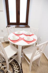 锡比乌Samuel House的白色的桌子、白色的椅子和红色的白桌布