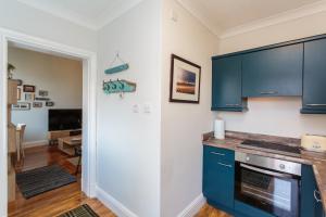 莱瑟姆-圣安妮Beach Hideaway的一间设有蓝色橱柜的厨房和一间客厅