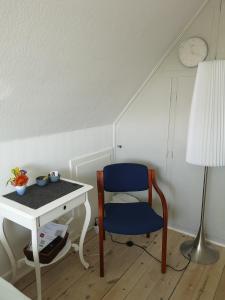 哈泽斯莱乌Rosenhuset的客房设有桌子、蓝椅和书桌。