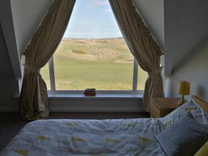 波特拉什Links Vista Portrush的一间卧室设有一张床和一个美景窗户。