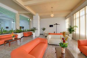卡塔赫纳Hotel Dorado Plaza Centro Histórico的大堂拥有橙色和白色的家具和植物