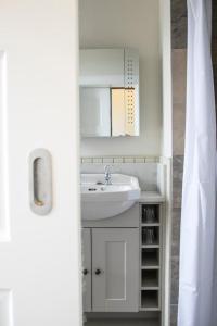托伯莫里Linndhu House的一间带水槽和白色橱柜的浴室