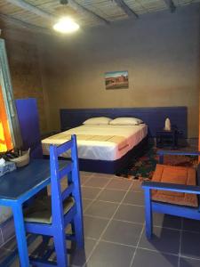 梅尔祖卡桑切斯优瑟夫酒店的一间卧室配有一张床和两张蓝色椅子