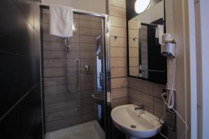博洛尼亚La Suite Rooms & Apartments的一间带水槽和淋浴的小浴室