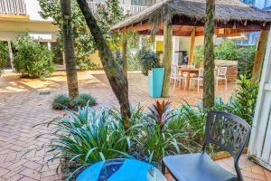 凯恩斯珊瑚树酒店的一个带桌椅的庭院和一个凉亭