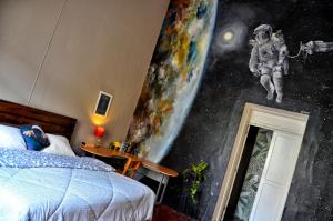 瓜达拉哈拉Hostel Hospedarte Centro的卧室的墙上挂有宇航员壁画