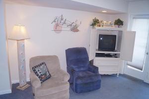 大洋城高点南3楼公寓的客厅配有两把椅子和电视
