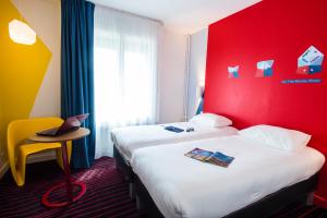 鲁昂Ibis Styles Rouen Centre Cathédrale的酒店客房设有两张床和红色的墙壁。